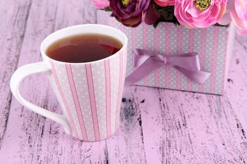 Fragrant tea with flowers on wooden table close-up