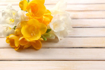 Beautiful freesia flowers, on wooden table