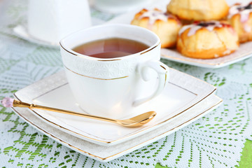 Cup of tea with sweet pastries on table close-up