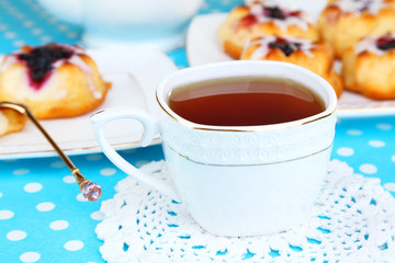 Cup of tea with sweet pastries on table close-up