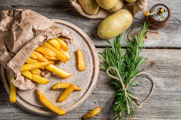 Homemade fries with salt served in paper