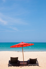 Sandy beach with umbrella and beach chair