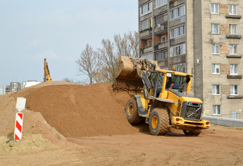 The wheel loader forms a sandy embankment