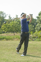 Golfer hits an fairway shot towards the club house