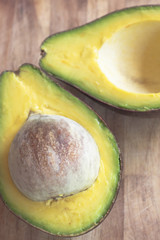 ripe avocado cut in half on a wooden table