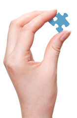 female arm holding blue puzzle piece