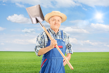 Mature agricultural worker holding shovel