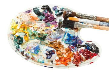 artistic pallette with oil paints and paintbrushes