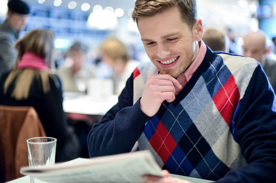 Stylish man reading newspaper at cafe