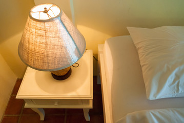Lamp on a night table next to a bed