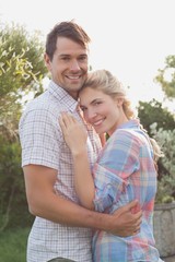 Fototapeta premium Smiling young couple embracing in the park
