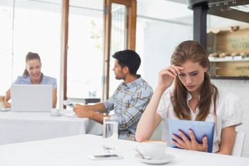 Woman using digital tablet in coffee shop