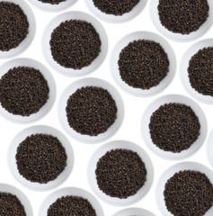 many black pepper in white cup on white background