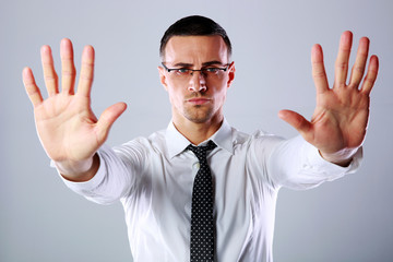 Confident businessman gesturing stop sign with both hands