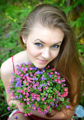 Fototapeta premium Beautiful young woman with the bouquet of spring flowers