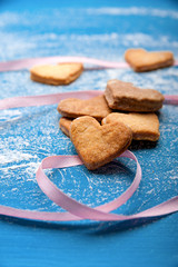 Cookie-hearts on a blue background with a pink ribbon