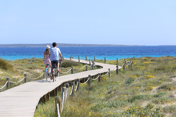 Couple riding bikes on Formentera Island - obrazy, fototapety, plakaty