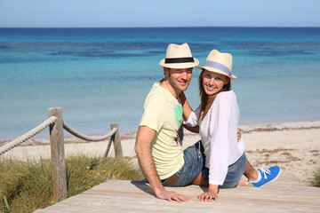 Couple on vacation sitting by the beach