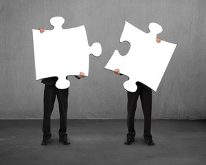 Men holding two puzzles