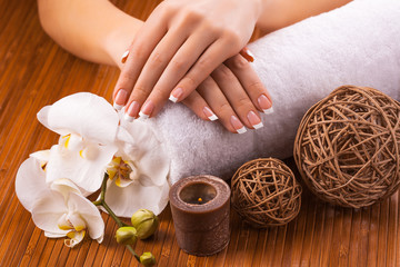 beautiful french manicure with white orchid  on a bamboo