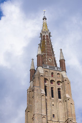 Fototapeta na wymiar Brickwork tower against cloudy sky Bruges
