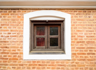 Fototapeta na wymiar Small wooden window and brick wall