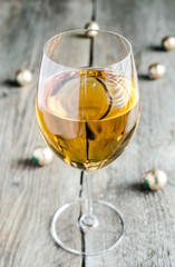 Wineglass with white wine and chocolate candies behind