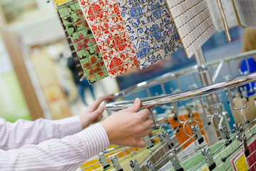 employee presenting colorful tiles in a supermarket