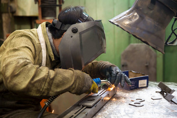 Fototapeta premium Industrial Worker Welder Welding Metal at Factory Workshop
