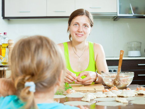  woman with  child cooking fish pelmeni
