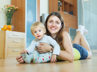long-haired mom and child on wooden floor