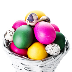 Colorful easter eggs in basket isolated on white background clos