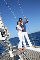 Fototapeta premium Fancy couple enjoying sailing on a beautiful sailboat