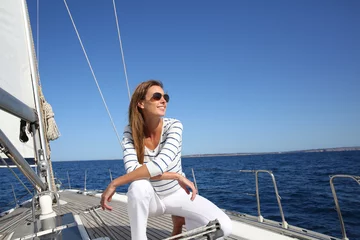 Abwaschbare Fototapete Segeln Attraktive moderne Frau, die Segelkreuzfahrt genießt