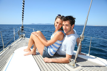 Obraz premium Happy couple navigating on sailboat