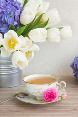 Obraz na płótnie Canvas antique cup of tea with tulips