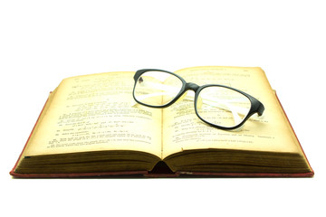 Old book and glasses isolated on white