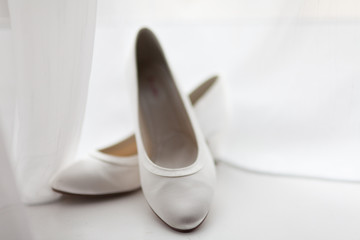 Hochzeit - Brautschuhe am Fenster vor Vorhang