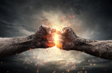 Fight, two fists hitting each other over dramatic sky - obrazy, fototapety, plakaty
