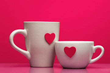 Cups with valentines day heart on pink background