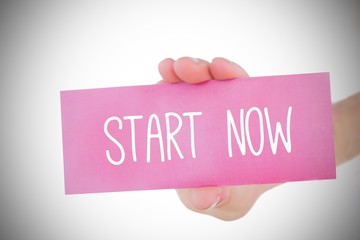 Woman holding pink card saying start now
