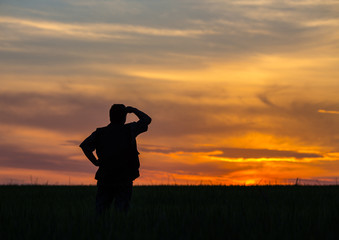 silhouette of man standing in a field