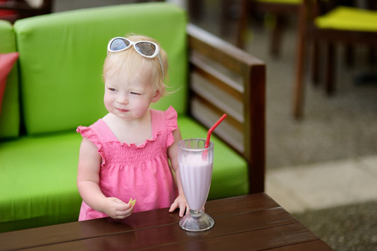 Little Girl Drinking Milkshake In A Restaurant