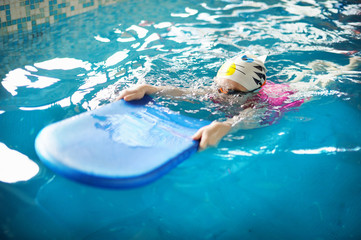 Happy little girl learning to swim