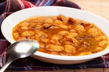 Beans with tomato sauce, bacon and sausage