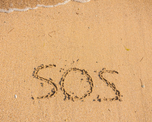 S.O.S written in the sand