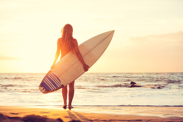 Surfer girl on the beach at sunset - 63938762