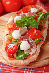 Homemade pizza with prosciutto and mozzarella