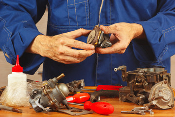 Mechanic repairing parts of the automobile engine in workshop