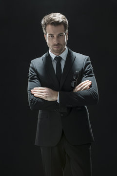 handsome man in black suit on a black background